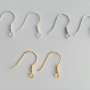 Op de afbeelding: Een set van zes oorhaken, vier zilver en twee goud. De haken zijn gemaakt van metaal en hebben een kleine lus aan de bovenkant.
