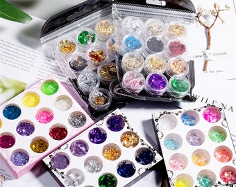 May include: Assortment of small jars filled with colourful glitter and metallic flakes. The jars are arranged in a grid pattern and are packaged in clear plastic bags. The jars are labelled with the words "Eternity Blossom" and "Vilena".