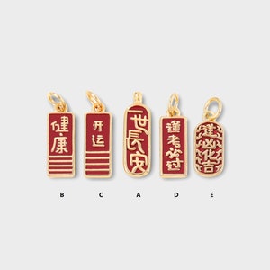 Puede incluir: Cinco amuletos de oro con esmalte rojo y caracteres chinos. Los amuletos están etiquetados de la A a la E. Los caracteres en los amuletos dicen: "世長安", "建凶化吉", "逢考必过", "开运", y "健康".
