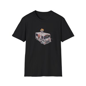 May include: Black t-shirt featuring a white ice cream van with a clown on top. The van has red and white polka dots and the clown has orange hair.