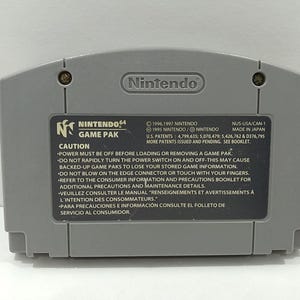 May include: A gray Nintendo 64 Game Pak cartridge. The back of the cartridge features the Nintendo logo, the Nintendo 64 Game Pak logo, and a caution label with safety instructions. Made in Japan.