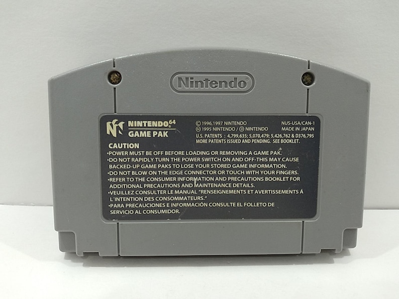 May include: A gray Nintendo 64 Game Pak cartridge. The back of the cartridge features the Nintendo logo, the Nintendo 64 Game Pak logo, and a caution label with safety instructions. Made in Japan.