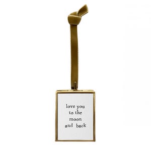 May include: Gold-toned metal frame with a white card inside. The card has the text "love you to the moon and back" written in black.
