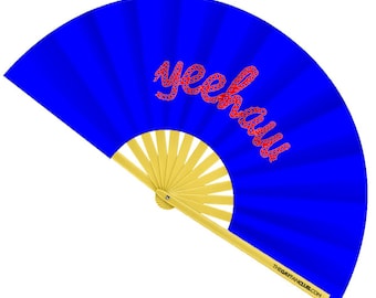 May include: A blue hand fan with the word "yeehaw" in red script. The fan's handle and the base are yellow. The text "THEGAYFANCLUB.COM" is printed on the handle.