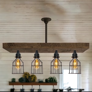 May include: A rustic, industrial-style light fixture with four Edison-style bulbs encased in black wire cages. The bulbs hang from a weathered wooden beam, suspended from the ceiling by a dark metal pipe and a circular ceiling mount. The fixture is designed for indoor use.