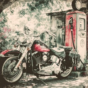 May include: A vintage motorcycle with a red fuel tank and chrome accents is parked next to an old-fashioned gas pump. The scene is set outdoors with trees and foliage, creating a nostalgic feel.