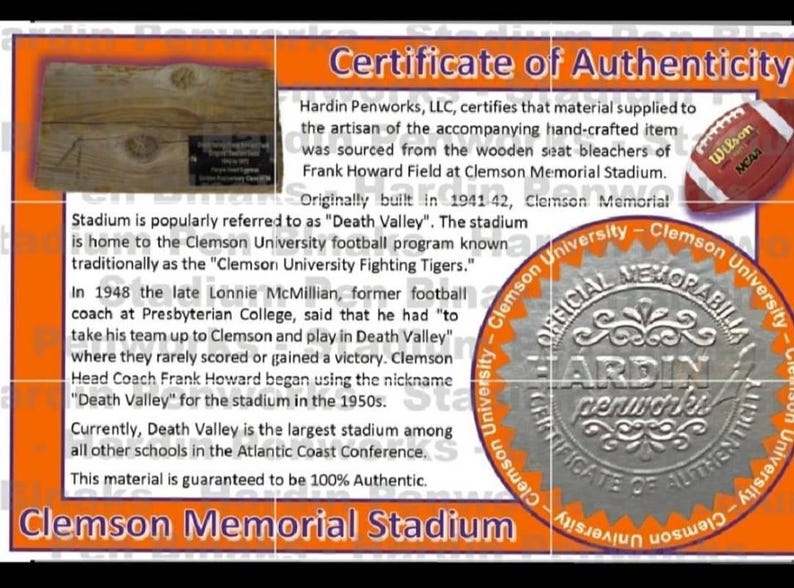 May include: Certificate of Authenticity for a Clemson Memorial Stadium item. The orange and white certificate includes text, a football, and a wooden section. The text mentions the stadium's history and the "Death Valley" nickname.
