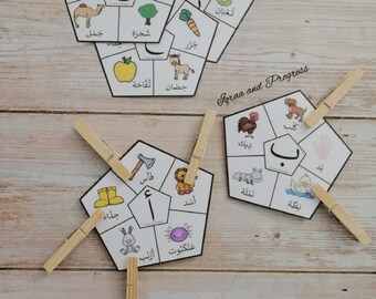 May include: A set of six colorful, illustrated cards with Arabic letters and words. Each card features a different letter of the Arabic alphabet, along with a picture and the corresponding word in Arabic. The cards are designed for children learning the Arabic alphabet.
