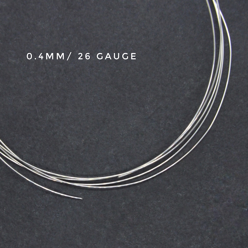May include: Close-up of silver wire, 0.4mm in diameter, or 26 gauge. The wire is coiled on a dark gray surface.