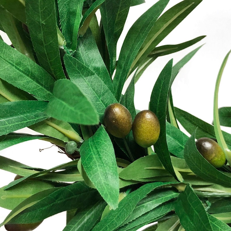 May include: An artificial olive branch featuring elongated, pointed green leaves and several small, round olives with a gradient of dark brown to yellowish-green coloring. The foliage is dense and layered, showcasing realistic textures and veins.