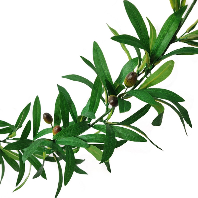 May include: A decorative artificial olive branch garland featuring elongated, pointed green leaves and small, round, dark brown olives attached to a flexible, thin stem. The foliage displays varied shades of green with visible vein details.