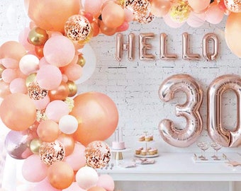 May include: A rose gold balloon arch with pink and white balloons, rose gold confetti, and the words "HELLO 30" in rose gold foil balloons.