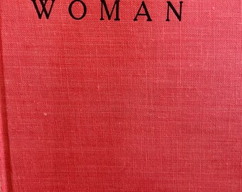 May include: Red book cover with the text "she shall be called WOMAN" in black.