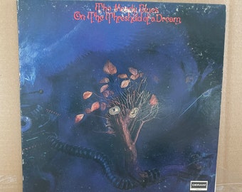 May include: A vintage vinyl record album cover featuring a dark blue background with a tree with brown branches and orange leaves. The album title is "The Moody Blues On The Threshold Of A Dream" and the record label is "Deram London".