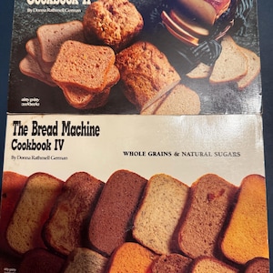 May include: Two cookbooks titled "The Bread Machine Cookbook II" and "The Bread Machine Cookbook IV" by Donna Rathmell German. The covers feature images of various types of bread, including loaves and slices, showcasing different textures and colors.