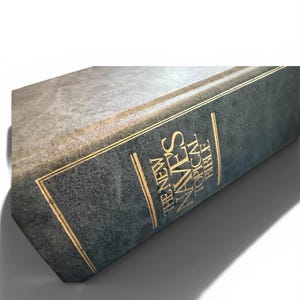 May include: Close-up of a hardcover book titled "The New Nave's Topical Bible." The book has a dark teal cover with gold lettering and accents. The book's spine is visible, casting a shadow on a white background.
