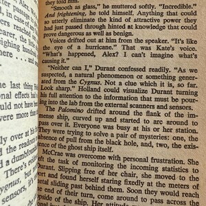 May include: Open book with text from a novel titled "The Black Hole." The text is in black font on aged, cream-colored paper. The page number "33" is visible. The text describes a science fiction scene with dialogue.