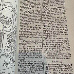 May include: An open book with text from the Bible, featuring a detailed illustration of a religious scene. The pages are aged, with visible text and a drawing of figures in the left margin.