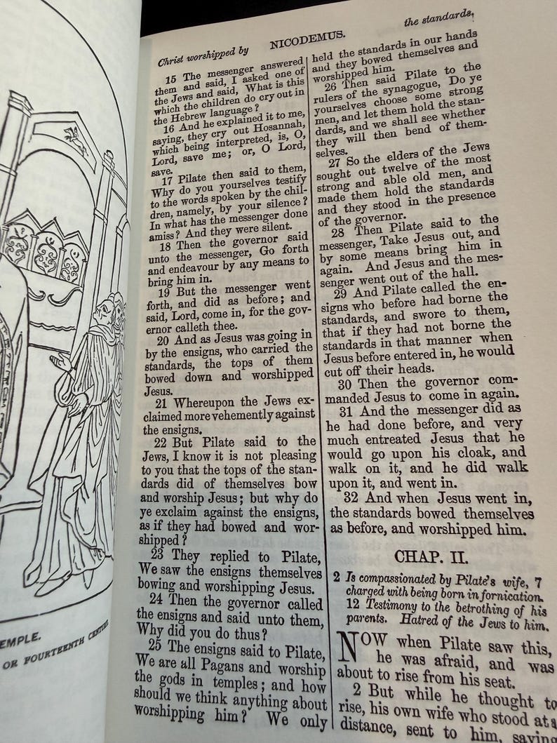 May include: An open book with text from the Bible, featuring a detailed illustration of a religious scene. The pages are aged, with visible text and a drawing of figures in the left margin.
