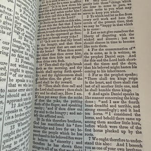May include: An open book displaying text from the Bible, with the headings "Prophecies in Daniel" and "Barnabas." The pages are aged, and the text is printed in black ink. The book is open to a chapter with multiple verses.