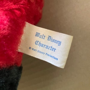 May include: A white tag with blue text that reads "Walt Disney Character &copy; Walt Disney Productions".