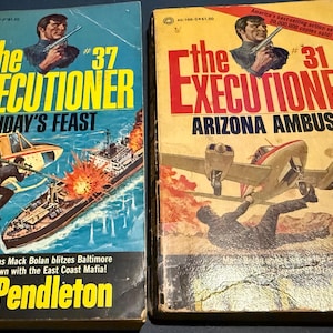 May include: Two vintage paperback books titled "The Executioner." One features a helicopter and a ship on fire, labeled "Friday's Feast." The other shows a plane and a falling figure, titled "Arizona Ambush."