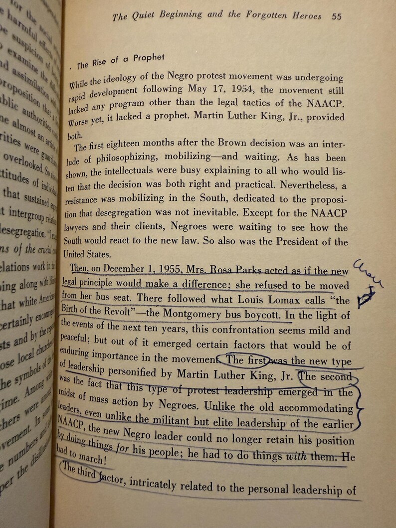 Op de afbeelding: Pagina uit een open boek met tekst over de opkomst van een profeet, waaronder Martin Luther King Jr. en de Montgomery-busboycot. Zwarte tekst op verouderd papier, met handgeschreven aantekeningen.