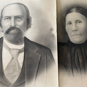 Puede incluir: Un retrato en blanco y negro de una pareja. El hombre lleva traje y corbata, y tiene barba. La mujer lleva un vestido oscuro con un cuello de encaje.