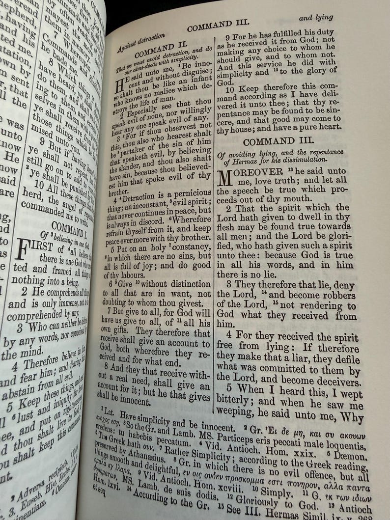May include: An open book displaying biblical text, with headings "COMMAND II" and "COMMAND III". The pages are aged, and the text is printed in black. The book is open to a specific passage, showing the text.