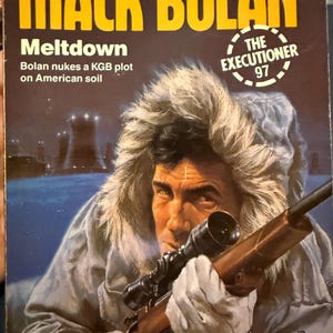 May include: Book cover for "Mack Bolan: Meltdown" by Don Pendleton. The cover features a man aiming a rifle with a scope, wearing a fur-lined parka. Text includes the title, author, and a tagline about a KGB plot.