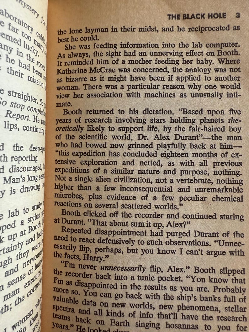 May include: Open book with text from a novel. The page shows a section titled "THE BLACK HOLE 3" with paragraphs of text. The text discusses scientific exploration and alien civilizations.