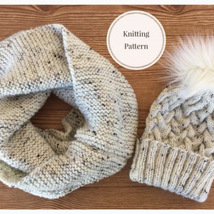 May include: A white knitted hat with a white pom pom and a matching white knitted scarf. The hat has a cable knit pattern. The scarf is a simple knit.
