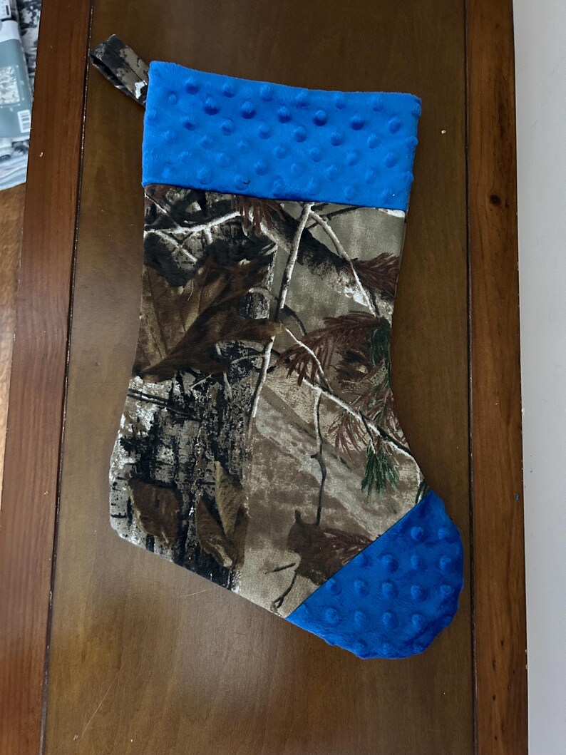 May include: Camouflage Christmas stocking with a blue fleece cuff and toe.