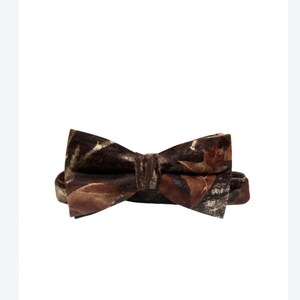 Puede incluir: Una pajarita marr&oacute;n con estampado de camuflaje. La pajarita est&aacute; hecha de un material suave y aterciopelado.
