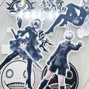 May include: A selection of anime-style stickers depicting characters in black attire, white hair, and blindfolds. One character is holding a sword. The stickers are on a white background and come in various shapes, including circles and decorative symbols.