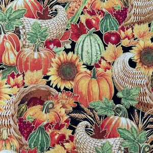 May include: A colorful autumn-themed fabric design featuring pumpkins, sunflowers, cornucopias, and fall foliage. The pumpkins are orange, green, and yellow, with red apples and grapes scattered throughout. The background is black.