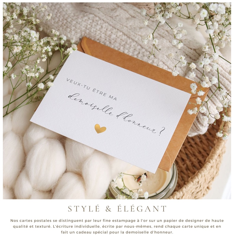 May include: A white card with gold foil accents and the text "VEUX-TU &Ecirc;TRE MA demoiselle d'honneur?"  The card is sitting on a brown envelope and a white knitted blanket.
