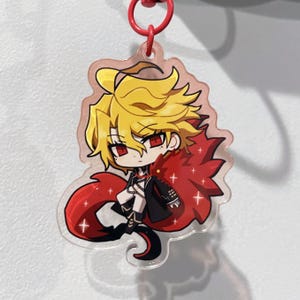 May include: A clear acrylic keychain featuring a cartoon character with yellow hair, red eyes, and a red cape. The character is wearing a black outfit and has a red keychain ring attached.