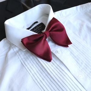 May include: A burgundy bow tie made of satin with a label that reads "Michelsons 1927 London Slim Fit".