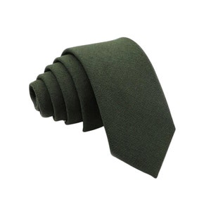 May include: A dark green solid colour tie made of a textured fabric.