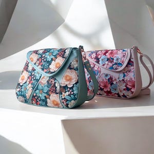 Könnte beinhalten: Zwei Handtaschen mit Blumenmuster, eine in blaugrün und die andere in rosa. Beide Taschen haben einen Klappverschluss und einen langen Riemen.