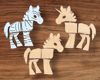 Pode incluir: Três quebra-cabeças de animais de madeira: uma zebra, um unicórnio e um cavalo. A zebra é branca com listras pretas. O unicórnio e o cavalo são castanhos claros. Os três são feitos de peças interligadas, sobre um fundo de grão de madeira.