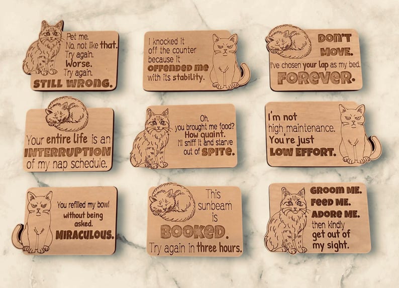 Nine wooden cat magnets with various cat illustrations and humorous sayings.
