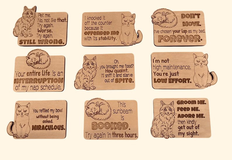 Nine wooden cat magnets with different cat illustrations and humorous sayings.