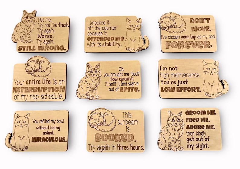 Nine wooden cat magnets with different cat illustrations and humorous sayings.