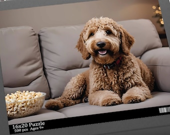 May include: A 500 piece jigsaw puzzle featuring a brown and white dog sitting on a gray couch with a bowl of popcorn in front of it. The puzzle box is black with the text "16x20 Puzzle 500 pcs Ages 9+"