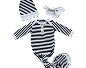 May include: A black and white striped knotted gown with long sleeves and a button closure. The gown comes with a matching hat and headband.