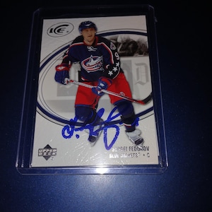 May include: A hockey trading card featuring Sergei Fedorov of the Columbus Blue Jackets. The card has a blue autograph and the Upper Deck logo. The player is wearing a red, white, and blue uniform and holding a hockey stick.