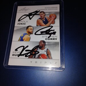 Nikola Jokic, Stephen Curry e Kevin Durant autografaram o cartão com COA