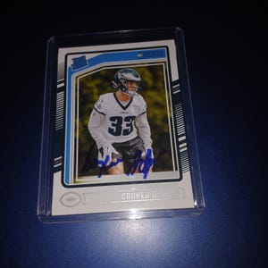 Tarjeta de novato autógrafa de Cooper Dejean con el logo